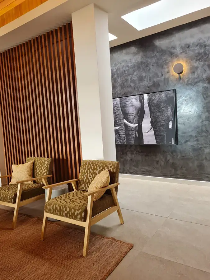 Modern custom home interior with textured wall, wood paneling, and designer furniture