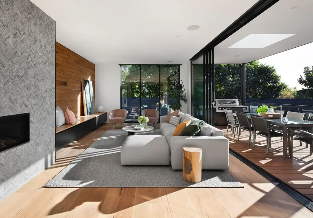 Modern open-plan living space with natural light and indoor-outdoor connection in a custom home