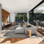 Modern open-plan living space with natural light and indoor-outdoor connection in a custom home
