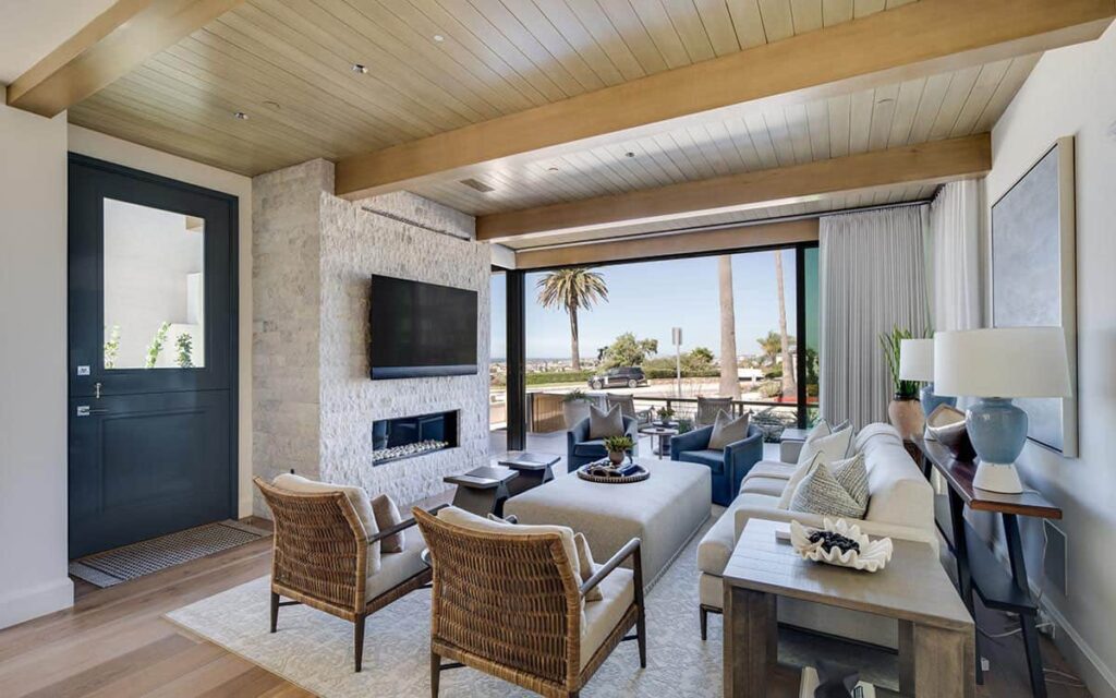 Custom home interior with wood beam ceiling, stone fireplace wall, and premium materials