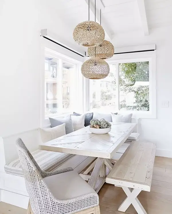 Light dining area with woven pendant lights and long wooden table