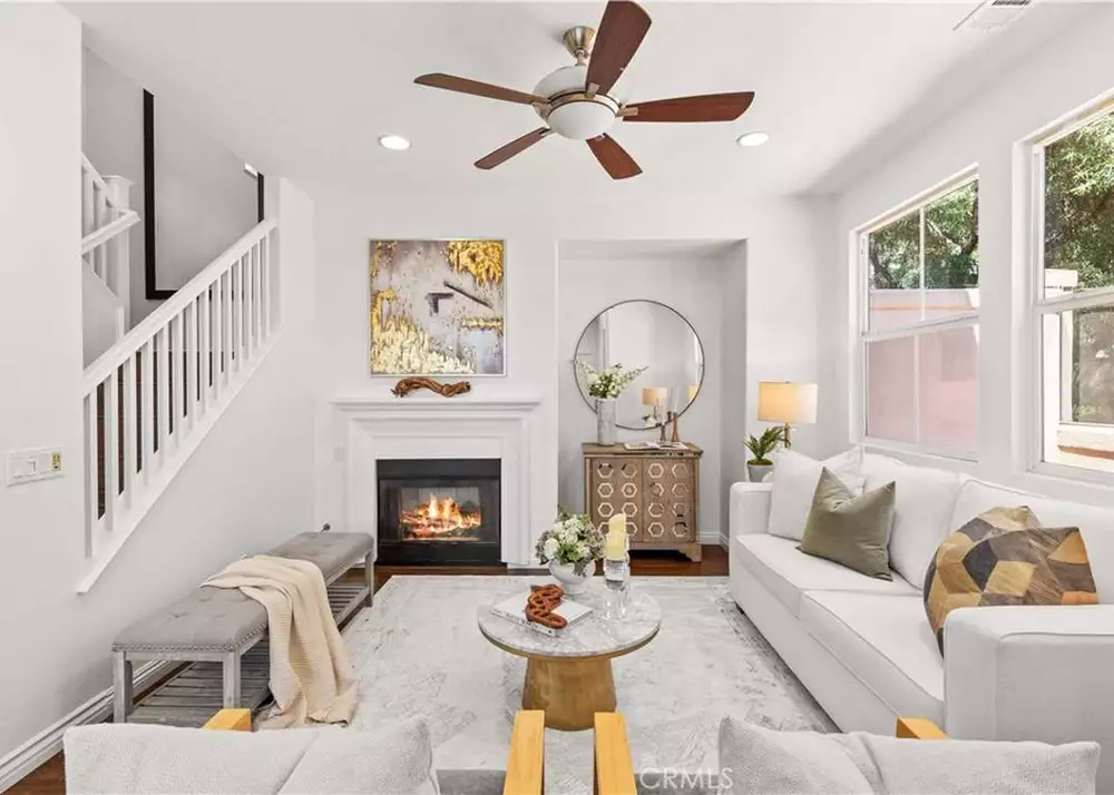 Cozy living room with fireplace, ceiling fan, and soft neutral decor