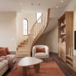 Living room with curved wooden staircase and natural light